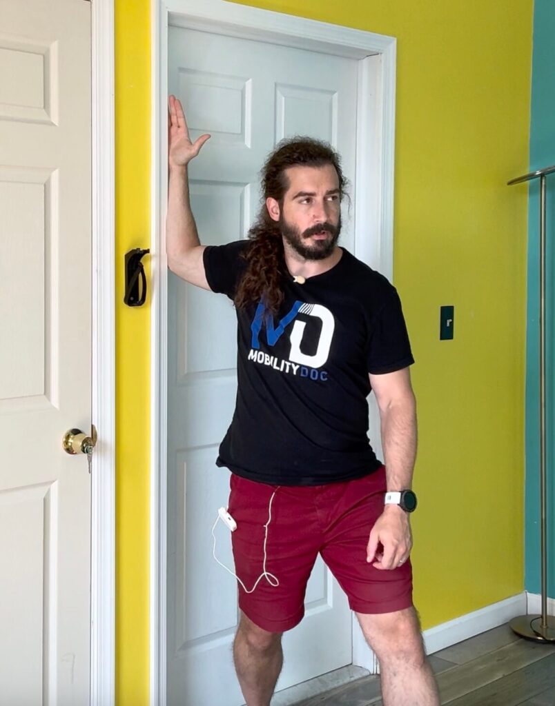 Using the door as leverage, Dr. John has his right arm in a 90 90 position in the door. He is turning his body away from the door to get a stretch in his pectoral muscle